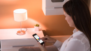 a lady sitting in her room using her phone with a table lamp showing stylish lamps 