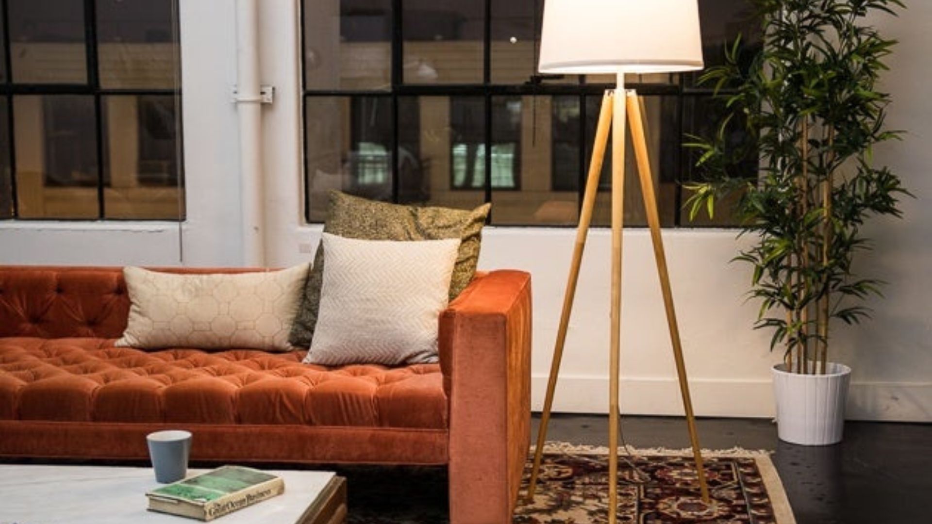 one of the best floor lamps for living rooms and a brown sofa with white cushions 
